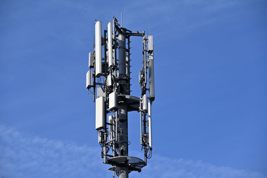 A modern cell tower with antennas against a clear blue sky, symbolizing connectivity.