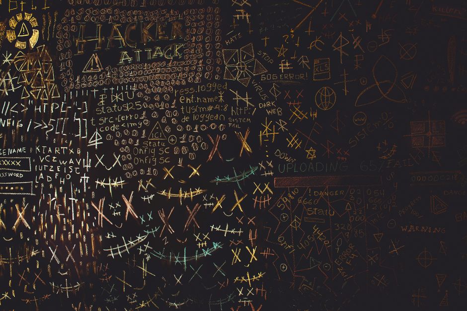 Complex chalkboard art featuring hacking symbols, codes, and geometric patterns.