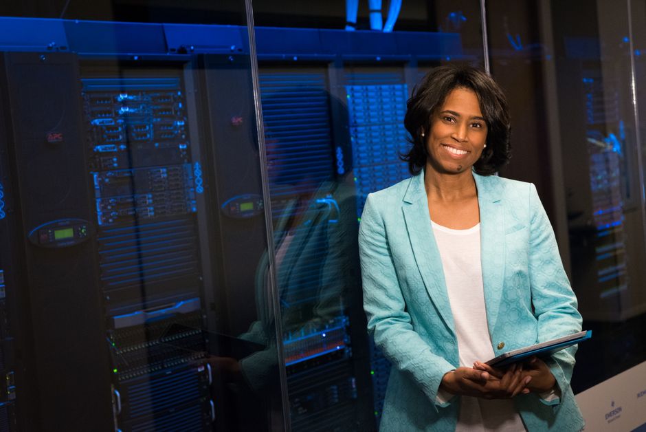 Smiling woman in data center showcasing technology expertise.