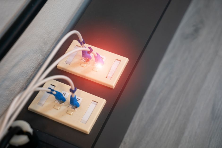 Close-up view of Ethernet ports with cables and illuminated LED indicator. Modern data connection setup.