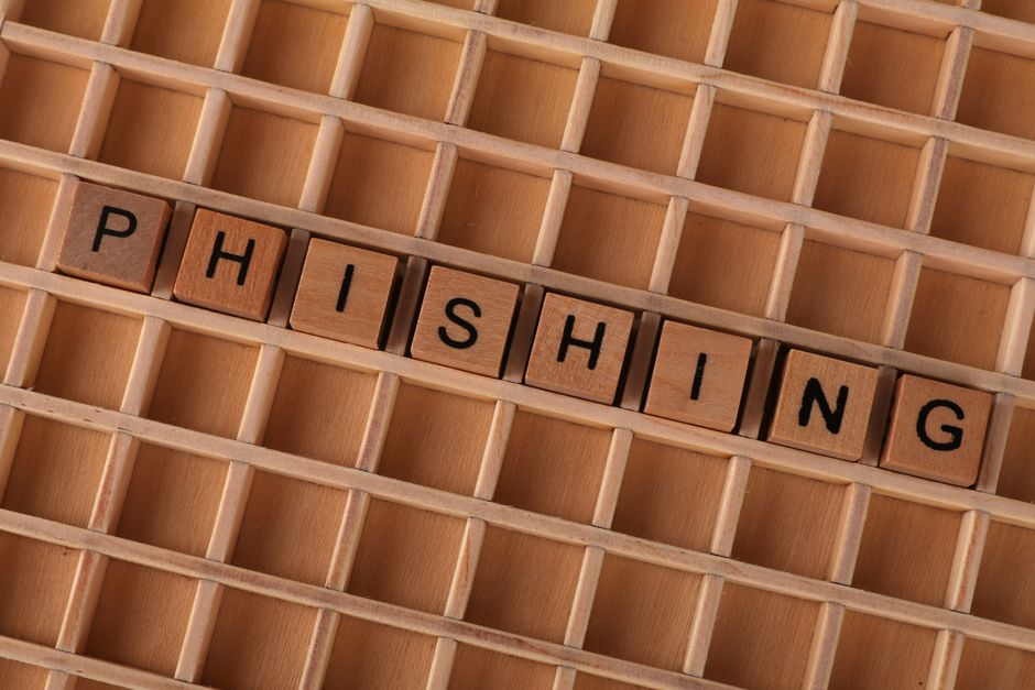 High-angle view of wooden letter tiles spelling 'Phishing', representing online security threats.