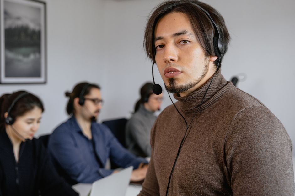 Focused call center team working attentively with headsets on in office.
