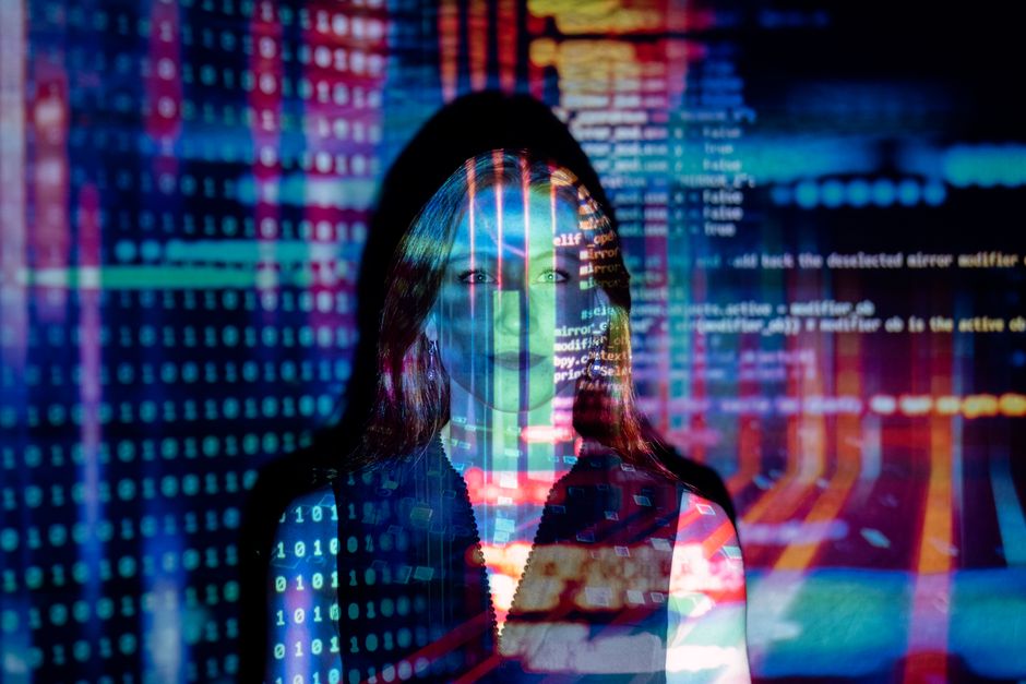 A woman with digital code projections on her face, representing technology and future concepts.