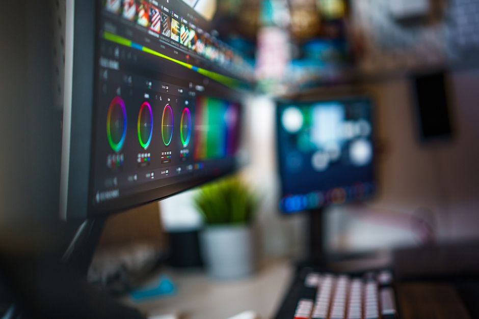 Modern video editing workspace with dual monitors showcasing color grading tools.